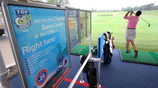 Golfer takes a swing at a Topgolf