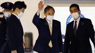 Japan's Prime Minister Yoshihide Suga (2nd-R) waves as he departs for the US from Tokyo's Haneda airport on April 15, 2021 to become the first foreign leader to hold talks with US president.