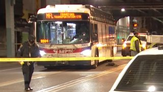 Crime scene tape surrounds a SEPTA bus as investigators walk around the street following a crash that killed a pedestrian in Philadelphia's Frankford neighborhood.