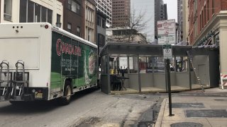A wooden pod sits next to a box truck in the middle of a Philadelphia street after the truck struck and dragged the pod.