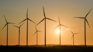 The sunrise shines colourfully behind the wind energy park “Odervorland” in the district Oder-Spree. On Friday, the Climate Cabinet in Germany will decide on a climate package that will include far-reaching measures for more climate protection.