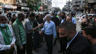 Top Hamas leader in Gaza, Yehiyeh Sinwar, center, pays his respects at a house of mourning for a Hamas commander killed in the war, in Gaza City