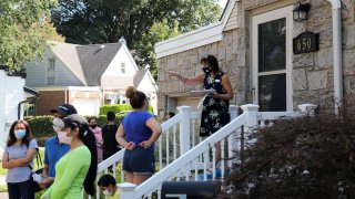 Robin Azougi 1st R, a licensed real estate salesperson with Douglas Elliman Real Estate, talks with prospective buyers at a house for sale in Floral Park, Nassau County, New York, on Sept. 6, 2020.