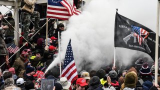 A supporter of U.S. President Donald Trump sprays smoke during a “Stop the Steal” protest outside of the Capitol building in Washington D.C. January 6, 2021.