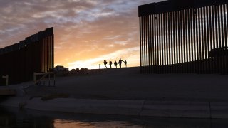 A pair of migrant families from Brazil pass through a gap in the border wall to reach the United States after crossing from Mexico in Yuma, Ariz., Thursday, June 10, 2021, to seek asylum. The families are part of an influx of asylum-seekers entering the U.S. in the Yuma area from South America and other continents.