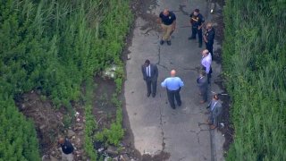 Law enforcement gather near a site where a woman's body was discovered in Chester, Pennsylvania, on June 22, 2021.