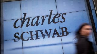 A pedestrian walks past a Charles Schwab office in New York.