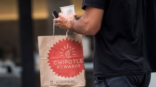 A customer carries a Chipotle Mexican Grill Inc. bag outside a restaurant in San Francisco, California, U.S., on Monday, July 20, 2020.