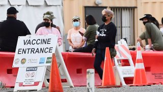 People wearing facemasks outdoors are seen at a Covid-19 vaccine site in Los Angeles, California on July 6, 2021.