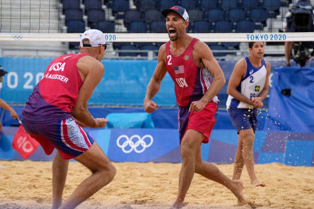 Nicholas Lucena, center, of the United States, celebrates with teammate Philip Dalhausser as Alvaro Morais Filho, right, of Brazil, watches during a men's beach volleyball match at the 2020 Summer Olympics, Tuesday, July 27, 2021, in Tokyo, Japan.