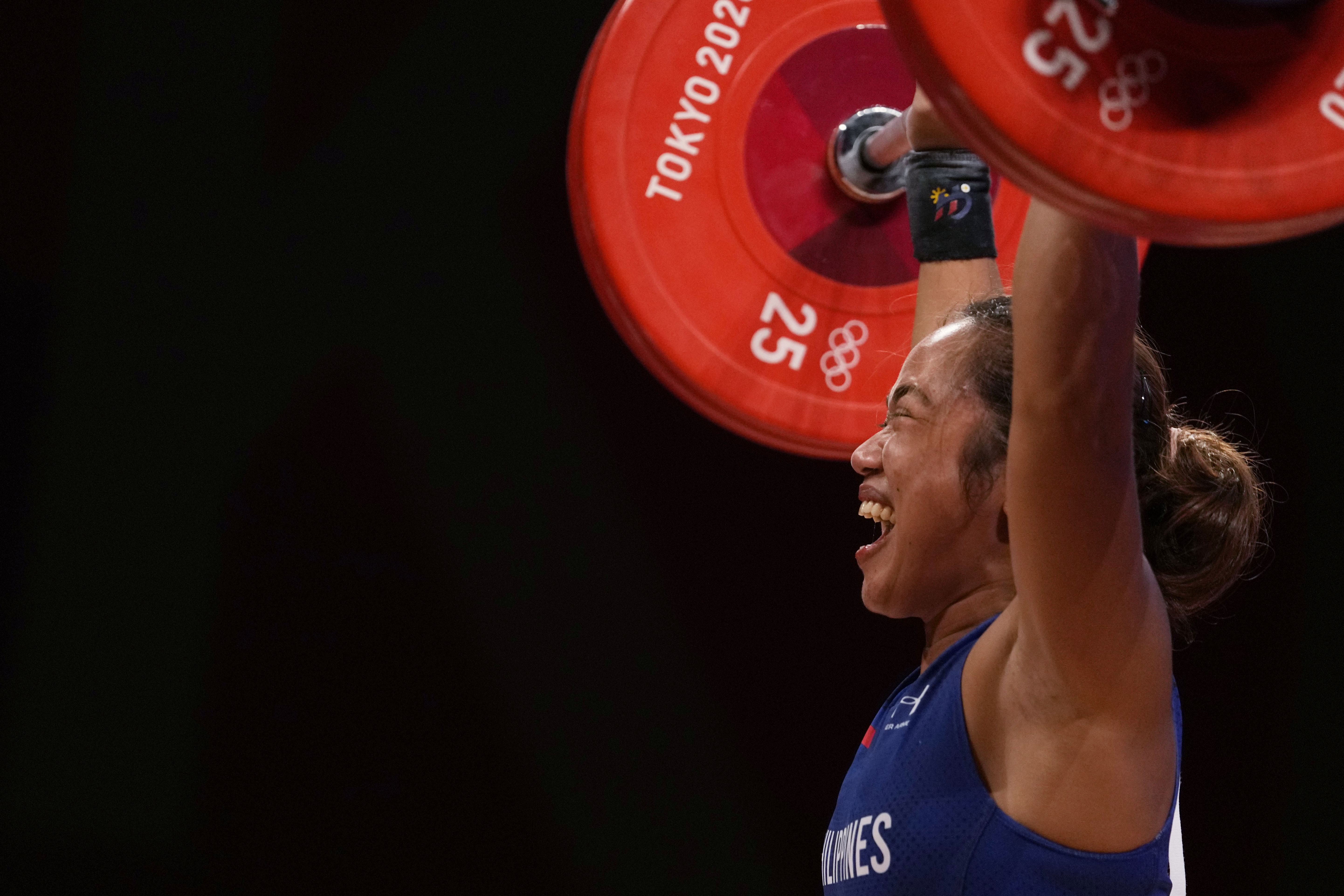 Hidilyn Diaz of Philippines celebrates as she competes and sets new world record and won the gold medal in the women's 55kg weightlifting event, at the 2020 Summer Olympics on July 26, 2021, in Tokyo, Japan.