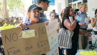 Joann Marcus of Fort Lauderdale, left, cheers as she listens to the Broward School Board's emergency meeting