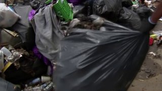 Trash bags being cleared from sidewalk