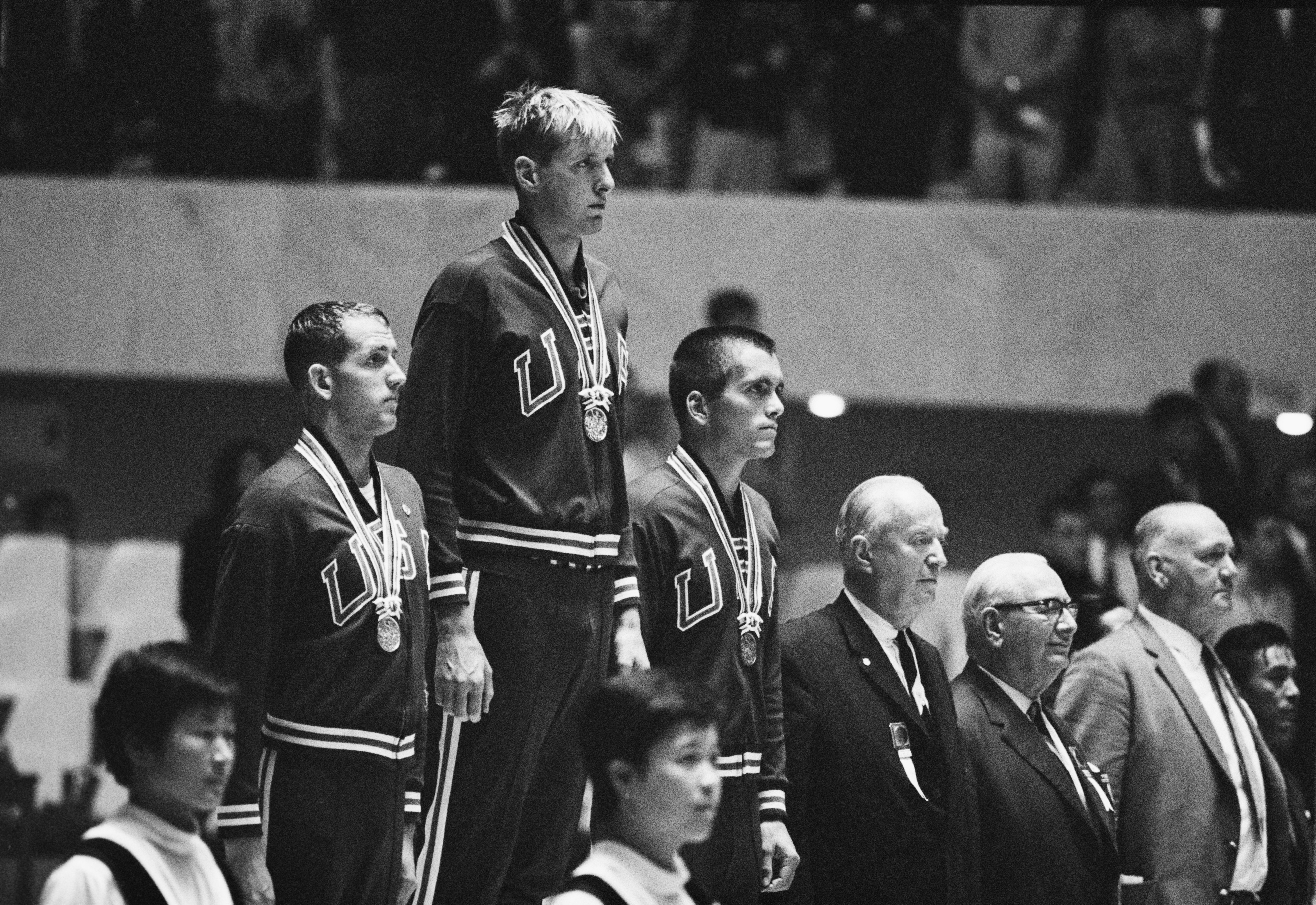 Jed Graef of the United States (centre) celebrates on the podium his gold medal with compatriot  silver medallist Gary Dilley (L) and bronze medallist Bob Bennett after the Men’s 200 metres Backstroke competition on 13th October 1964 during the XVIII Summer Olympic Games at the Yoyogi National Gymnasium in Shibuya, Tokyo, Japan.