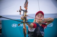 Casey Kaufhold aims bow and arrow