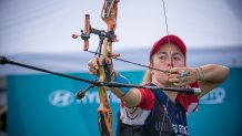 Casey Kaufhold aims bow and arrow