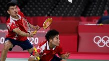 China's Wang Yilyu (L) hits a shot next to China's Huang Dongping in their mixed doubles badminton