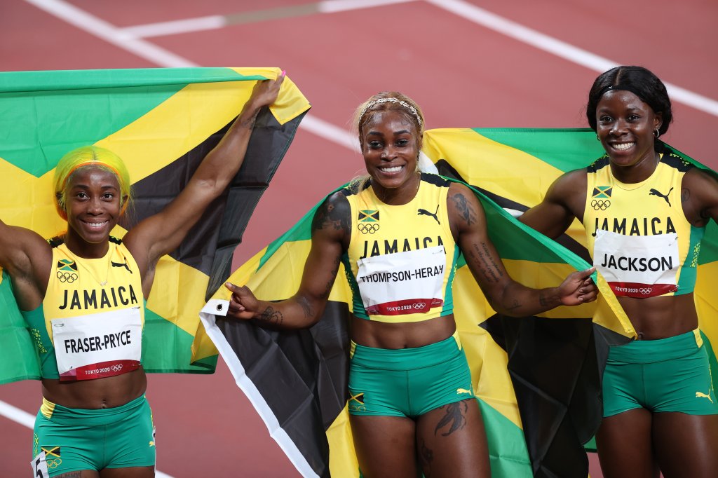 From left: Jamaica's runner-up Shelly-Ann Fraser-Pryce, first-place finisher Elaine Thompson Herah and third-place finisher Shericka Jam Jackson celebrate with flags after the women's 100-meter, July 31, 2021, Tokyo, Japan.