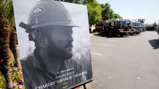 SAN BERNARDINO, CALIFORNIA - SEPTEMBER 25: A photograph of fallen Big Bear Interagency Hotshot Charles Morton, a firefighter who was killed battling the El Dorado wildfire, is displayed at a memorial service for Morton on September 25, 2020 in San Bernardino, California. Morton was a 14-year veteran with the U.S. Forest Service. The El Dorado fire has scorched more than 22,000 acres in Southern California.