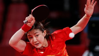 Red-clad Chen Meng of China watches her shot in a semifinal versus Germany