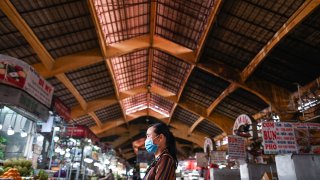 A woman walks inside the Ben Thanh market in Ho Chi Minh City on June 27, 2020.