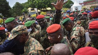 CONAKRY, Guinea – Lieutenant Colonel Mamady Doumbouya, head of the army’s special forces and coup leader, waves to the crowd as he arrives at the Palace of the People in Conakry on September 6, 2021, ahead of a meeting with the Ministers of the Ex-President of Guinea, Alpha Conde.