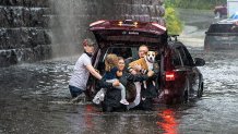 These people walk away from a flooded vehicle in Caln Township, Chester County, on Sept. 23, 2021.