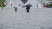 A man and young girl make their way through the flooded Main