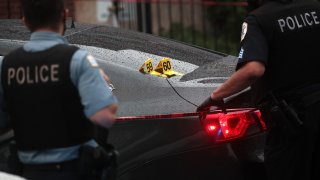 Shell casings labeled 59 and 60 rest on a bullet-riddled car as police investigate the scene of a shooting in the Auburn Gresham neighborhood on July 21, 2020 in Chicago, Illinois.