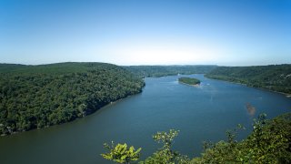 Trees line the Susquehanna River in PA, USA on a summer autumn day.