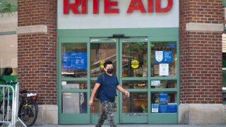 Rite Aid pharmacy sign with person walking in front