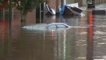 The roof of an almost fully submerged car can be seen after flooding in Philadelphia's Manayunk neighborhood on Thursday, Sept. 2, 2021. Debris can also be seen in the background.