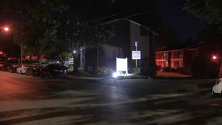 A light shines in front of a sign placed in front of a Philadelphia apartment complex.