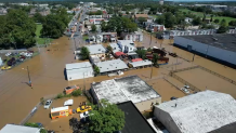 An aerial view of Wilmington, Delaware, shows the tops of buildings and homes surrounded by floodwaters.