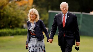 U.S. President Joe Biden and U.S. first lady Jill Biden walk after arriving in the Marine One helicopter on the South Lawn of the White House