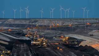 Lignite mining taking place in Germany with wind turbines in the background.