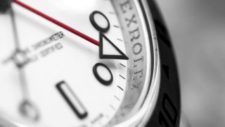 A macro of a Rolex Explorer II GMT watch.