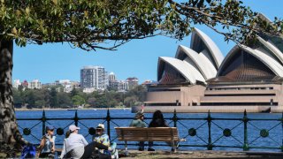 People gather for picnics beside the Harbour Bridge in the suburb of Kirribilli on September 19, 2021 in Sydney, Australia. Covid-19 restrictions have eased for people in NSW who are fully vaccinated.