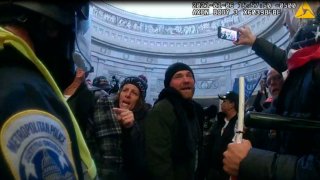 This image from Metropolitan Police Department body worm camera video and contained in the Statement of Facts supporting an arrest warrant for Pauline Bauer, pointing second to left, taken in the Rotunda of the U.S. Capitol on Jan. 6, 2021, in Washington