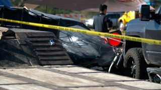 In this photo provided by Louis Amestoy, a police officer stands watch over the scene of a fatal drag racing crash at the Kerrville-Kerr County Airport in Kerrville, Texas