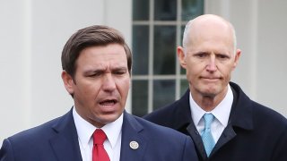 Florida Governor Ron DeSantis, left, flanked by Sen. Rick Scott (R-Fla.), speaks to the media after a meeting with President Donald Trump regarding Venezuela on Jan. 22, 2019, in Washington, D.C.