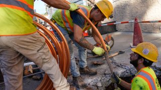 Workmen prepare to replace older water pipes with a new copper one in Newark, N.J.