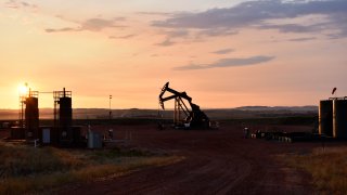 An oil well works at sunrise