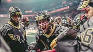 Philadelphia Wings captain Kiel Matisz wears a helmet as he speaks to teammates during a game.