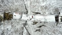 In this aerial image taken with a drone, vehicles rest on a bridge following its collapse, Friday Jan. 28, 2022, in Pittsburgh. The bridge spanning a ravine collapsed, requiring rescuers to rappel nearly 150 feet, while others formed a human chain to help rescue multiple people from a dangling bus. The collapse early Friday came hours before President Joe Biden was to visit the city to press for his trillion infrastructure bill, which includes bridge maintenance. (AP Photo/Gene J. Puskar)