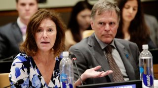 FILE- In this May 3, 2018 file photo, Fred Warmbier, right, listens as his wife Cindy Warmbier, speaks of their son Otto Warmbier, during a meeting at the United Nations headquarters. A federal judge has ruled that the parents of Otto Warmbier, a U.S. student who died after being taken hostage by North Korea and released by the country in a coma in 2017, should receive about $240,000 seized from a North Korean bank account. The amount would be a partial payment toward the more than $501 million Fred and Cindy Warmbier of Wyoming, Ohio, were awarded in 2018 by a federal judge in Washington, D.C.