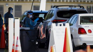 A healthcare worker administers a Covid-19 test at a drive-thru testing site at Tropical Park in Miami, Florida, U.S., on Thursday, Jan. 6, 2022.