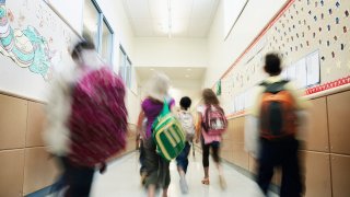 Young students walking down hallway of school