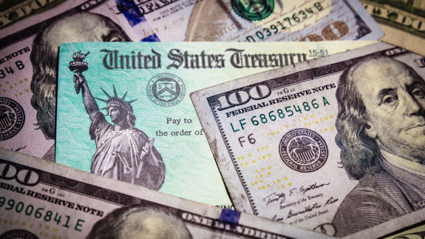 WASHINGTON DC – APRIL 2, 2020: United States Treasury check with US currency. Illustrates IRS tax refund or coronavirus economic impact stimulus payments to taxpayers affected by the pandemic.