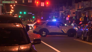A Philadelphia police SUV with its lights on blocks off a section of road.